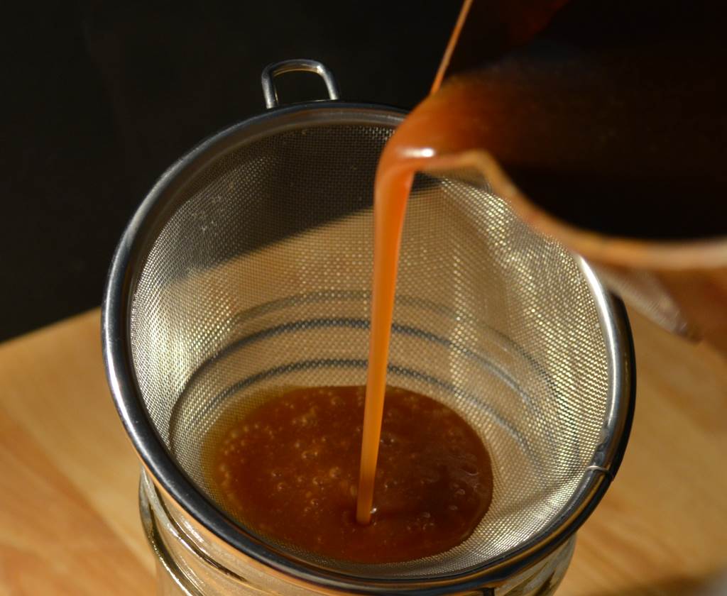 straining-caramel-sauce-into-jar